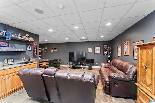 tiled living room featuring wet bar and a drop ceiling