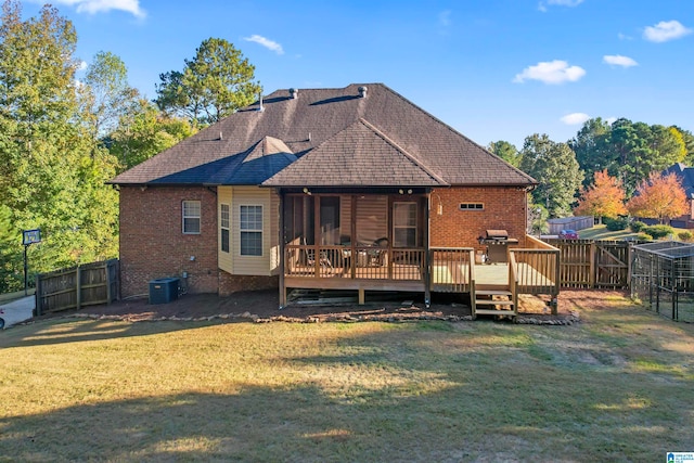 rear view of property featuring central air condition unit, a deck, and a lawn