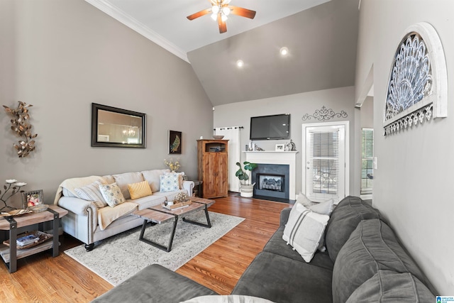 living room with crown molding, hardwood / wood-style floors, high vaulted ceiling, and ceiling fan