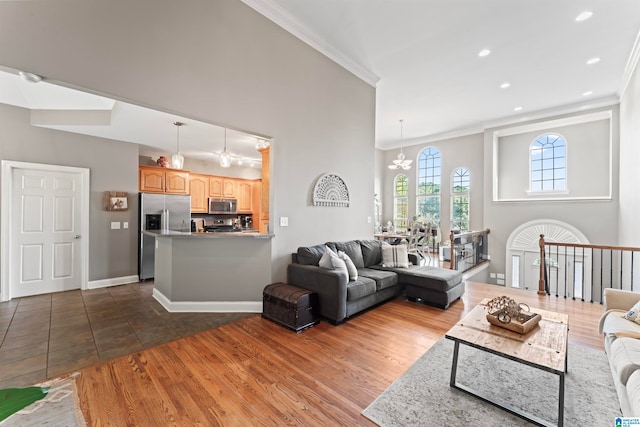 living room with a notable chandelier, ornamental molding, and dark hardwood / wood-style flooring