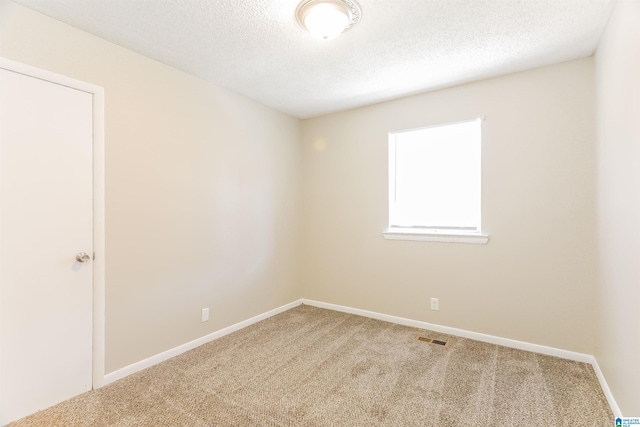 carpeted spare room featuring a textured ceiling