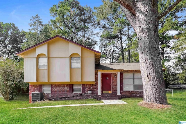 tri-level home featuring a front lawn and cooling unit