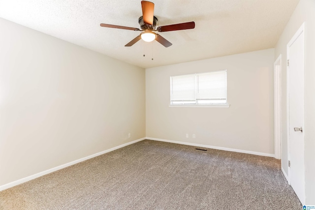 carpeted spare room with ceiling fan and a textured ceiling