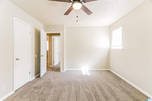 spare room featuring ceiling fan, carpet floors, and a textured ceiling