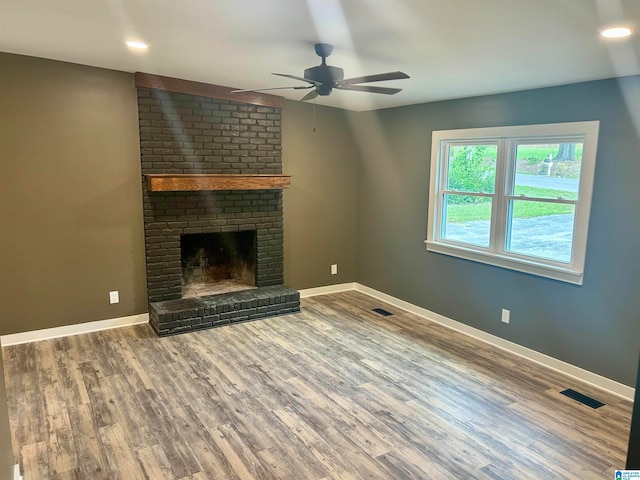 unfurnished living room featuring a fireplace, ceiling fan, and wood-type flooring