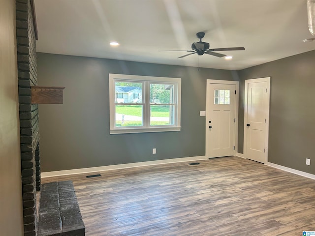 foyer featuring ceiling fan, a fireplace, and hardwood / wood-style floors