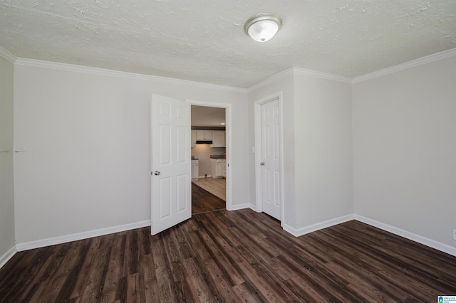 empty room featuring dark wood-type flooring, ornamental molding, and a textured ceiling