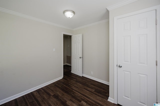 empty room with crown molding and dark hardwood / wood-style flooring