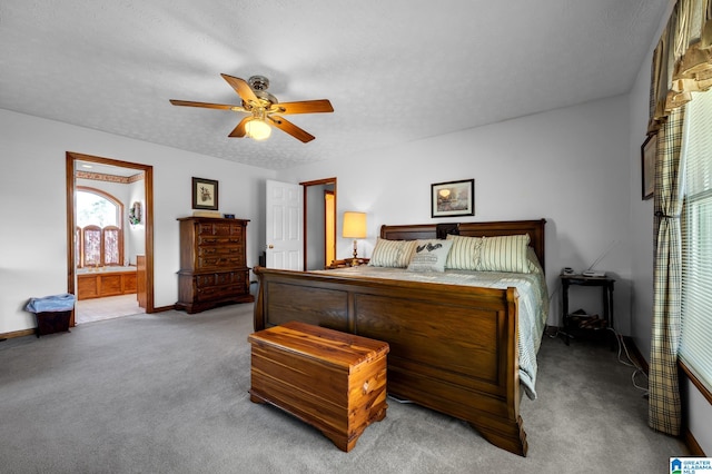 bedroom featuring a textured ceiling, ensuite bath, carpet flooring, and ceiling fan