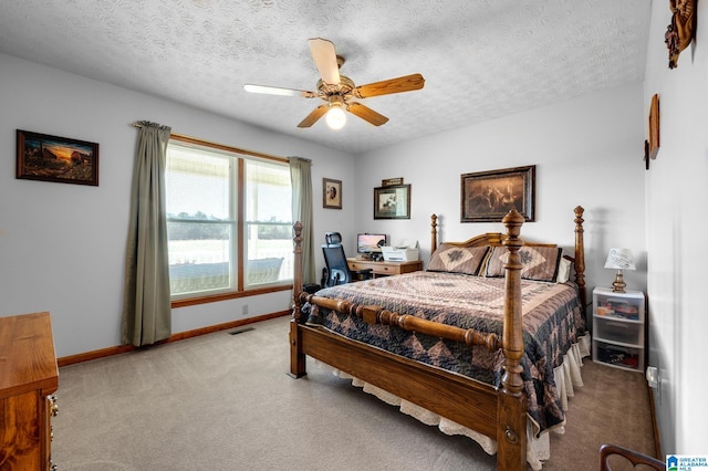 bedroom with ceiling fan, carpet flooring, and a textured ceiling