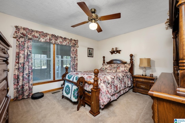 carpeted bedroom with ceiling fan and a textured ceiling