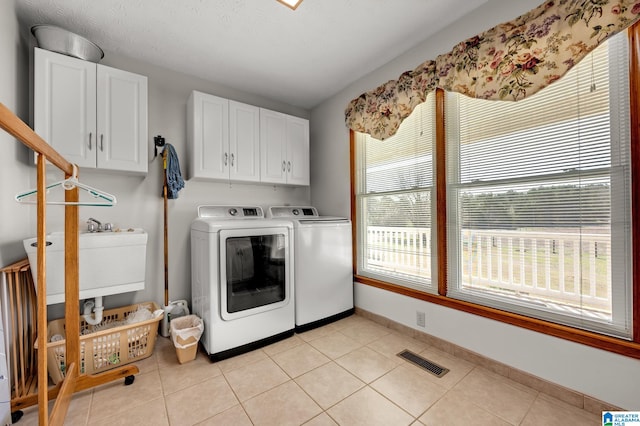 laundry room featuring separate washer and dryer, cabinets, sink, and light tile patterned floors