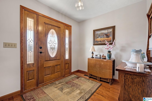 foyer entrance with light hardwood / wood-style floors and a textured ceiling