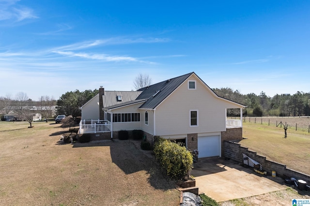 back of property featuring a garage and a lawn