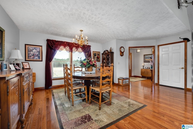 dining room with a chandelier, hardwood / wood-style flooring, and a textured ceiling