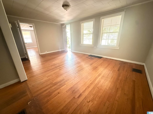 unfurnished room with ornamental molding, hardwood / wood-style flooring, and a wealth of natural light