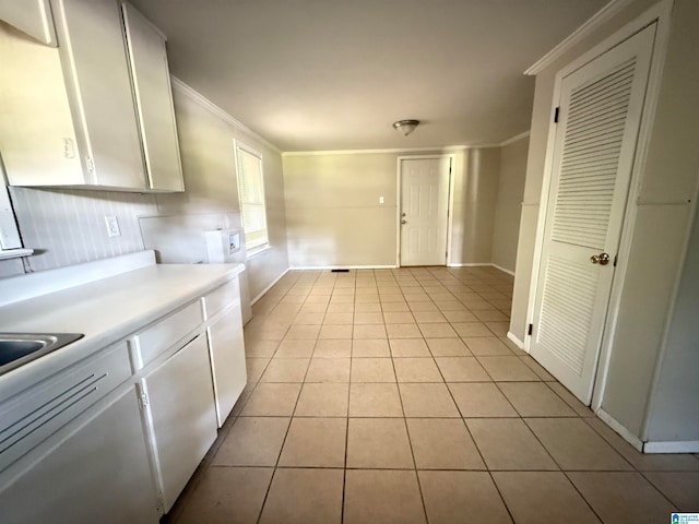 kitchen with crown molding, white cabinetry, and light tile patterned floors