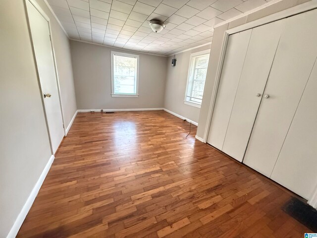 unfurnished bedroom featuring ornamental molding and hardwood / wood-style floors