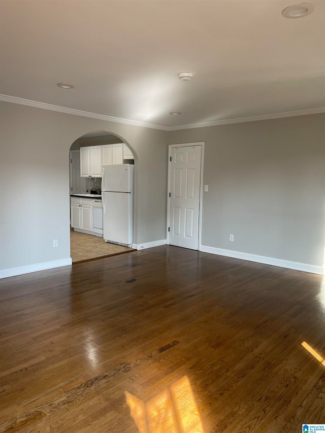 unfurnished living room featuring ornamental molding and dark hardwood / wood-style flooring