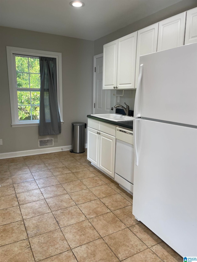 kitchen with sink, white appliances, white cabinets, and light tile patterned floors