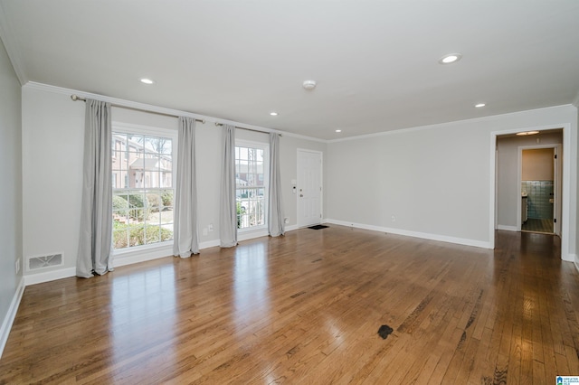 empty room with crown molding and hardwood / wood-style floors