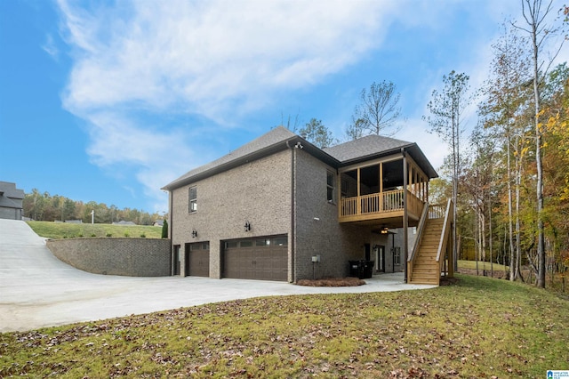 back of property with a lawn, a wooden deck, and a garage