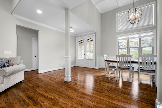 dining space featuring a wealth of natural light, crown molding, dark wood-type flooring, and an inviting chandelier