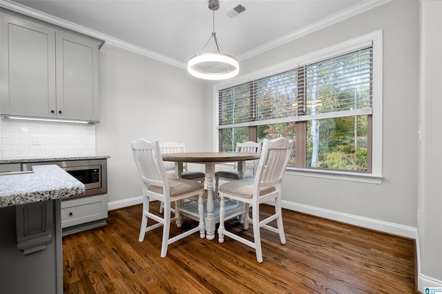 dining space featuring dark hardwood / wood-style flooring and ornamental molding