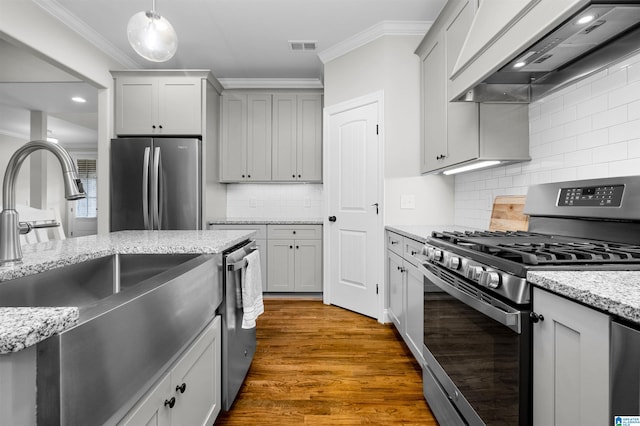 kitchen featuring premium range hood, dark wood-type flooring, gray cabinets, appliances with stainless steel finishes, and decorative light fixtures