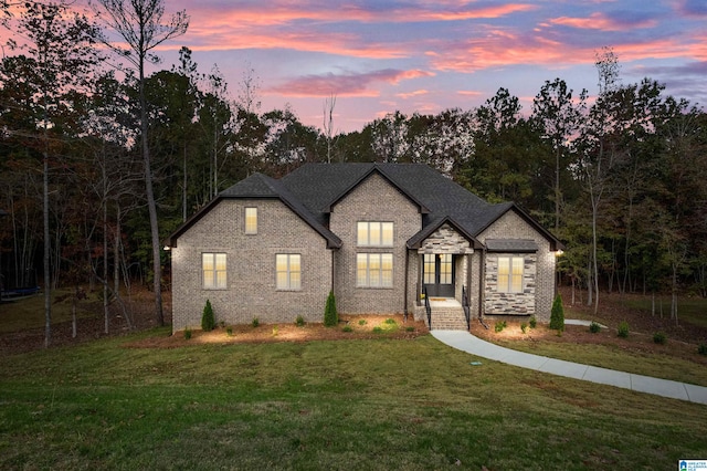 french country inspired facade featuring a lawn