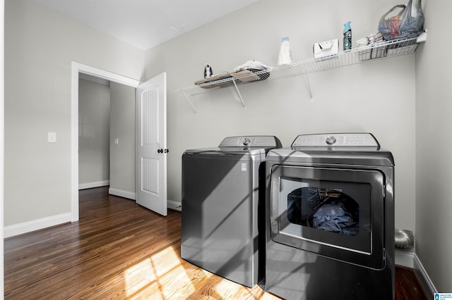 clothes washing area featuring washing machine and dryer and dark hardwood / wood-style floors