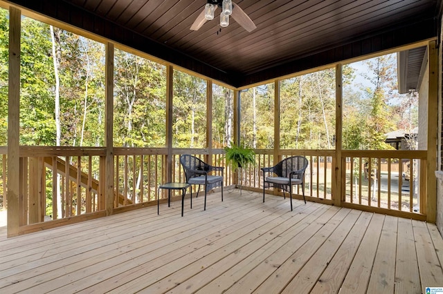 unfurnished sunroom featuring a wealth of natural light, wooden ceiling, and ceiling fan