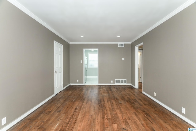 empty room featuring dark wood-type flooring and ornamental molding