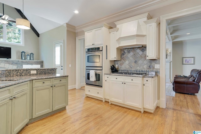 kitchen with pendant lighting, custom exhaust hood, light hardwood / wood-style flooring, stainless steel appliances, and decorative backsplash