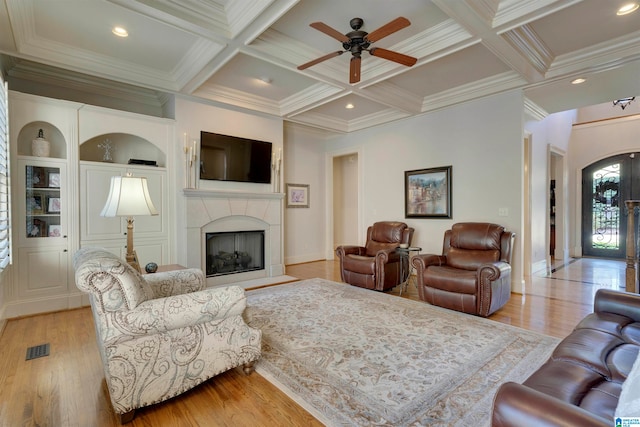 living room with crown molding, coffered ceiling, beamed ceiling, and light hardwood / wood-style flooring