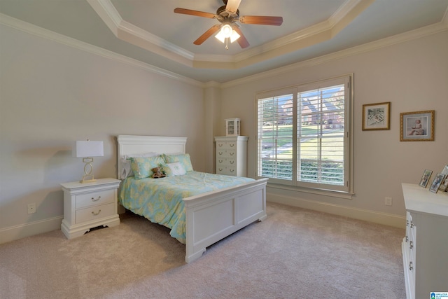 bedroom with a tray ceiling, crown molding, light colored carpet, and ceiling fan