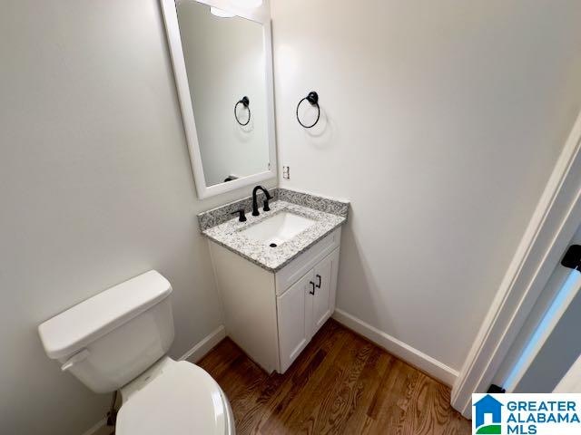 bathroom featuring vanity, hardwood / wood-style floors, and toilet