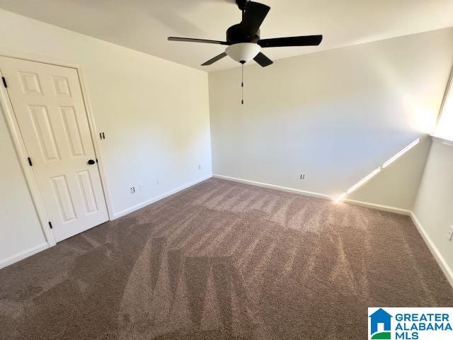 carpeted spare room featuring ceiling fan