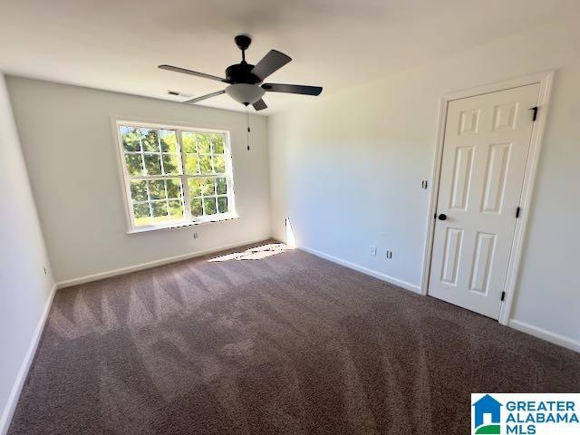 spare room with ceiling fan and carpet