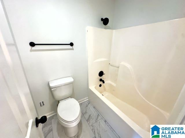 bathroom featuring shower / bathing tub combination and toilet