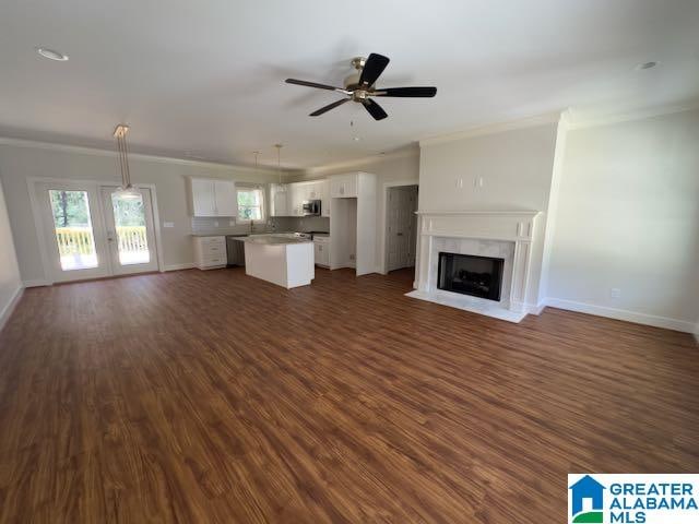 unfurnished living room with ornamental molding, ceiling fan, french doors, and dark hardwood / wood-style floors