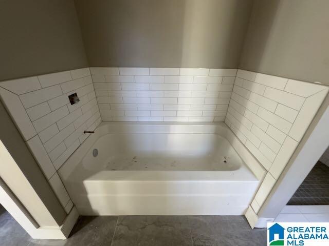 bathroom featuring tile patterned flooring and a bathing tub