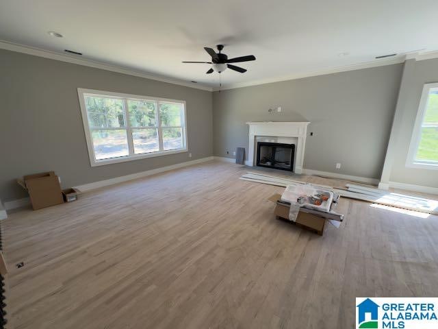 unfurnished living room featuring ornamental molding, ceiling fan, and light hardwood / wood-style flooring