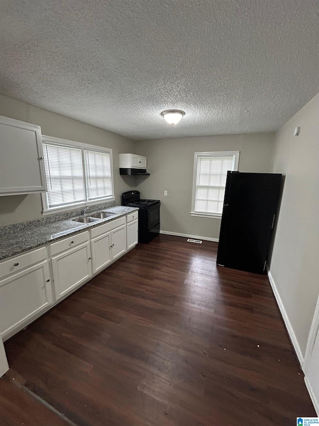 kitchen with a textured ceiling, black appliances, dark wood-type flooring, and white cabinets