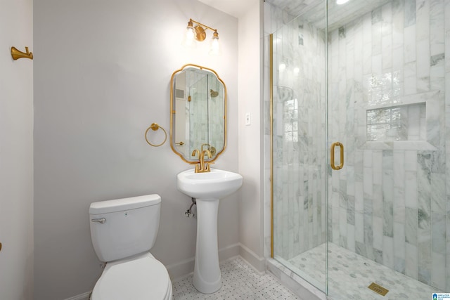 bathroom with a shower stall, toilet, and baseboards