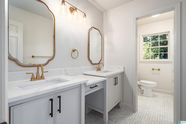 full bathroom with toilet, vanity, and baseboards