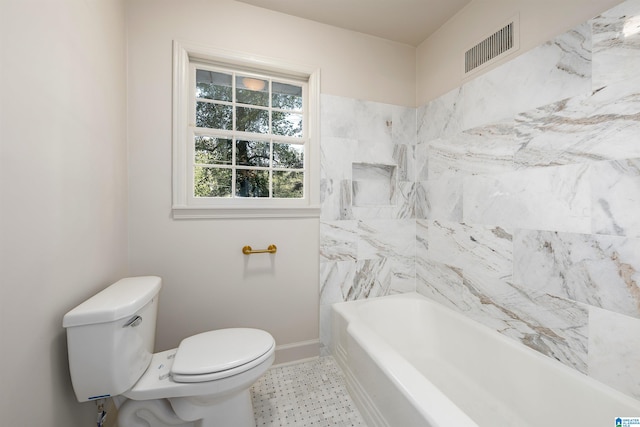 full bathroom featuring toilet, a bathing tub, visible vents, and baseboards