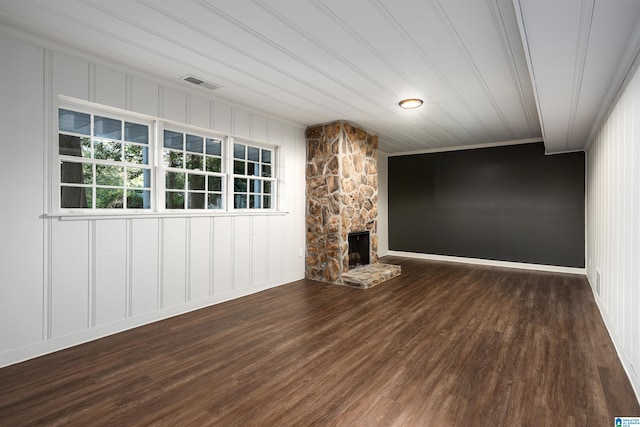 unfurnished living room with dark wood-style floors, a fireplace, and visible vents