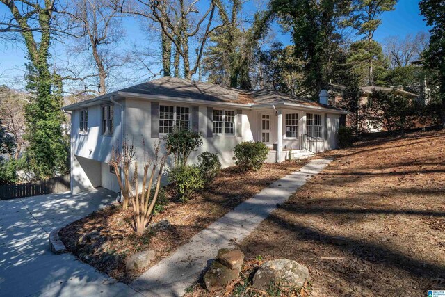 view of front facade featuring driveway, a porch, an attached garage, and brick siding