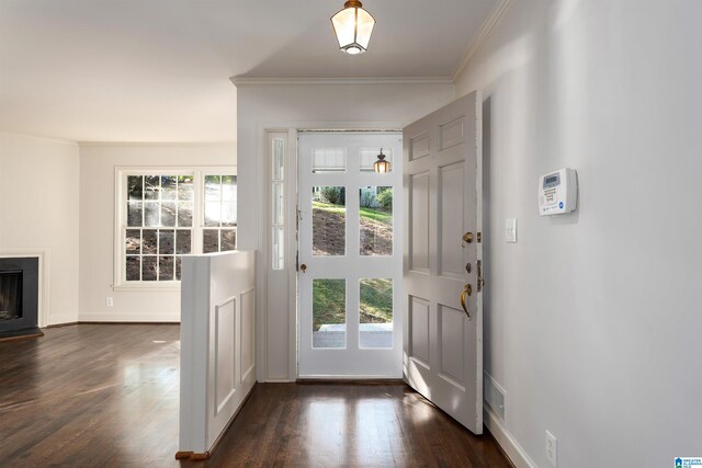 entryway with baseboards, dark wood-style flooring, a fireplace, and crown molding